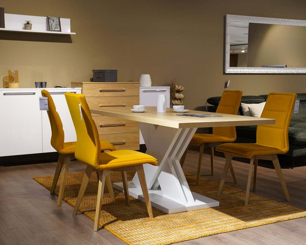 Ambiente montado em loja de móveis, com mesa de jantar branca e cadeiras amarelas